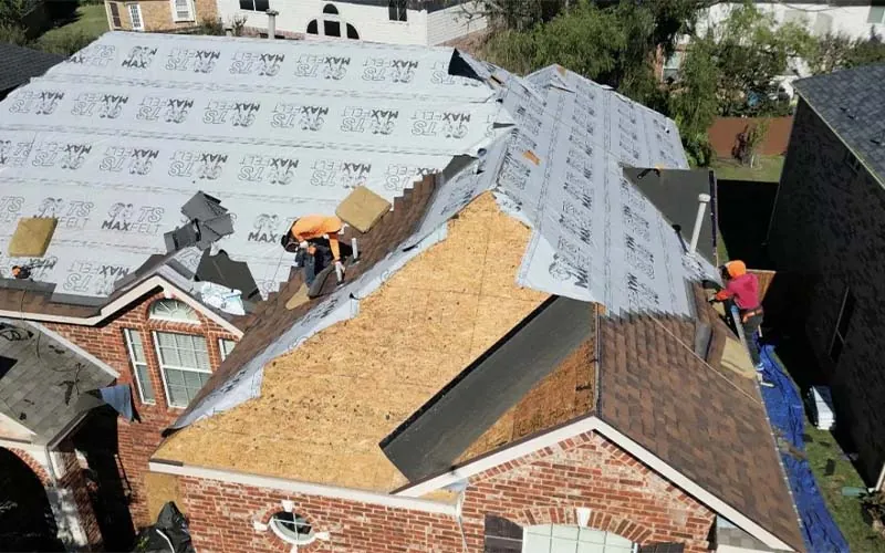 Drone photo of a Legacy crew tearing off an old roof and laying new underlayment